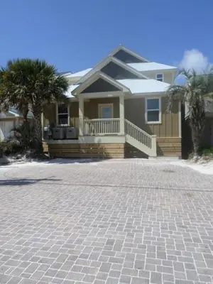 a house with a brick driveway in front of it at The Lighthouse 6 Bd Home With Beachfront Pool And Hot Tub in Panama City Beach