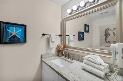 a bathroom with a sink and a large mirror at Shores Of Panama Best 3 Bedroom With Wrap-Around Balcony! in Panama City Beach