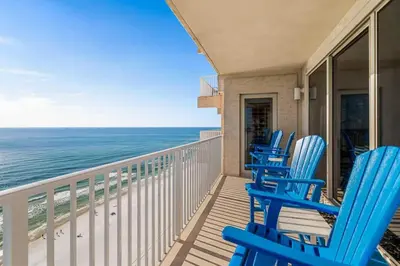 three blue chairs on a balcony overlooking the ocean at Shores Of Panama Best 3 Bedroom With Wrap-Around Balcony! in Panama City Beach