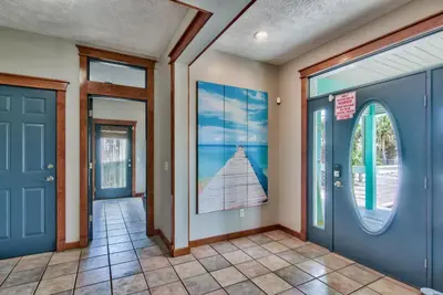 a hallway with a blue door and windows at Beachcomber - Beachfront With Pool And Hot Tub - On The Beach! in Panama City Beach