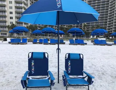 a group of blue chairs and an umbrella on the beach at Deluxe Beachfront Studio, Shores of Panama, Oceanviews and Updated in Panama City Beach