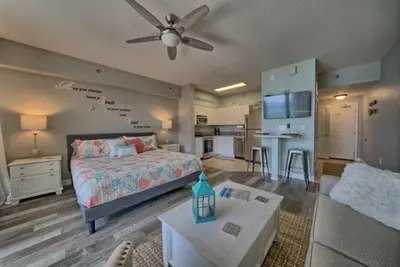 a bedroom with a bed and a living room at Deluxe Beachfront Studio, Shores of Panama, Oceanviews and Updated in Panama City Beach