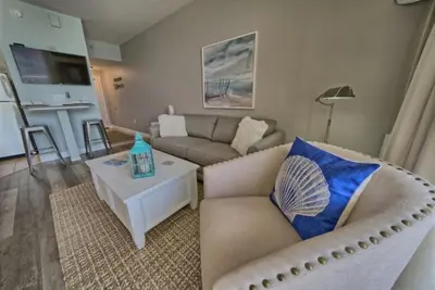 a living room with a couch and a table at Deluxe Beachfront Studio, Shores of Panama, Oceanviews and Updated in Panama City Beach