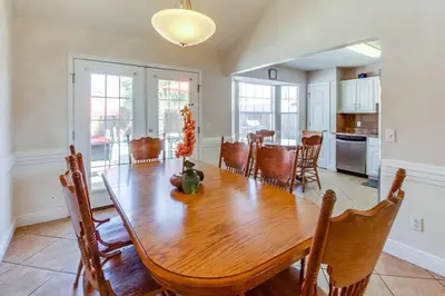 a kitchen and dining room with a wooden table and chairs at Gulf View Home - Private Pool! in Panama City Beach