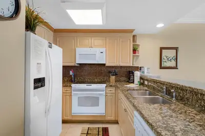 a kitchen with a white refrigerator and a sink at Boardwalk 805 in Panama City Beach