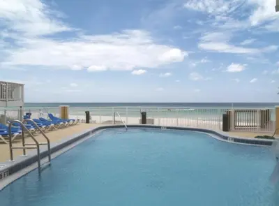 a swimming pool with a view of the beach at Tropic Winds Condo in Panama City Beach