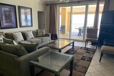a living room with a couch and a glass table at Tropic Winds Condo in Panama City Beach
