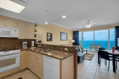 a kitchen and dining room with a view of the ocean at Boardwalk 1405 in Panama City Beach