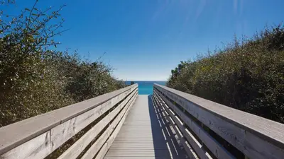a wooden boardwalk leading to the ocean on the beach at Four Fish Bungalow 155 in Santa Rosa Beach