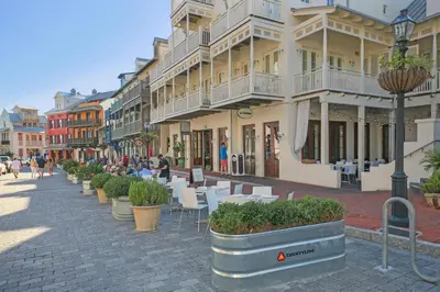 a city street with tables and chairs and buildings at Four Fish Bungalow 155 in Santa Rosa Beach