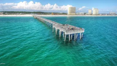 an aerial view of a pier in the water with a beach at Sun Of A Beach - Beautiful Home Next To Pier Park - Swimming Pool! in Panama City Beach