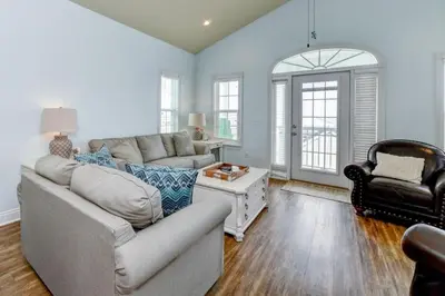 a living room with a couch and a chair at Sun Of A Beach - Beautiful Home Next To Pier Park - Swimming Pool! in Panama City Beach
