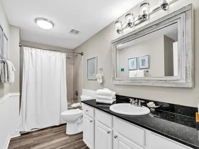 a bathroom with a sink and a toilet and a mirror at Calypso 2-1902 West in Panama City Beach