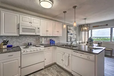 a kitchen with white cabinets and white appliances at Pinnacle Port Getaway with Ocean View and Pool Access! in Panama City
