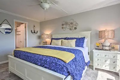 a bedroom with a bed with blue comforter and two lamps at Pinnacle Port Getaway with Ocean View and Pool Access! in Panama City