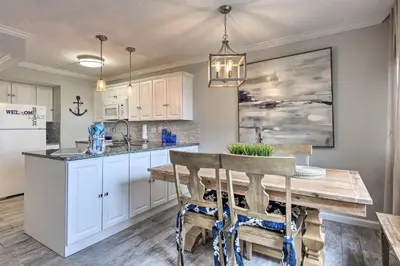 a kitchen with a wooden table and a refrigerator at Pinnacle Port Getaway with Ocean View and Pool Access! in Panama City