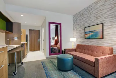 a living room with a couch and a kitchen at Home2 Suites By Hilton Panama City Beach, Fl in Panama City Beach