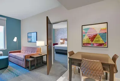 a living room with a couch a table and a bed at Home2 Suites By Hilton Panama City Beach, Fl in Panama City Beach