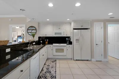 a kitchen with white cabinets and a white refrigerator at Treasure Island 0205 in Panama City Beach