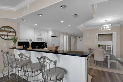 a kitchen and dining room with a bar and chairs at Treasure Island 0205 in Panama City Beach