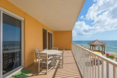 a balcony with a table and chairs and the ocean at Treasure Island 0207 in Panama City Beach