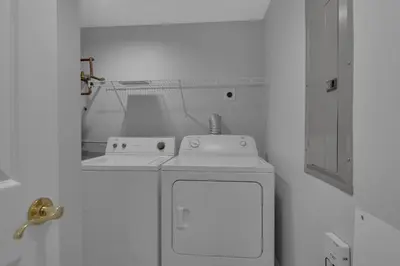 a white bathroom with a sink and a mirror at Treasure Island 0207 in Panama City Beach