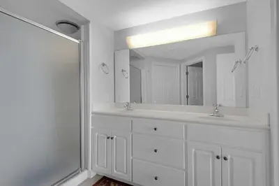 a white bathroom with two sinks and a mirror at Treasure Island 0207 in Panama City Beach