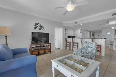 a living room with a blue couch and a tv at Treasure Island 0207 in Panama City Beach