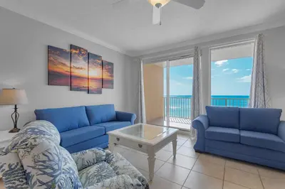 a living room with blue couches and a view of the ocean at Treasure Island 0207 in Panama City Beach