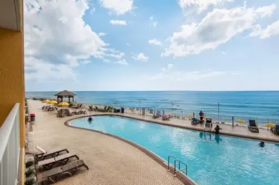 a swimming pool with the ocean in the background at Treasure Island 0210 in Panama City Beach