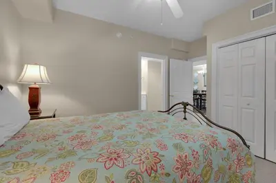 a bedroom with a bed with a flowered blanket at Treasure Island 0210 in Panama City Beach