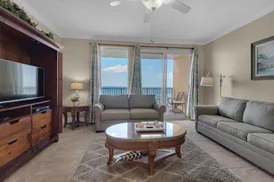 a living room with a couch and a tv at Treasure Island 0210 in Panama City Beach