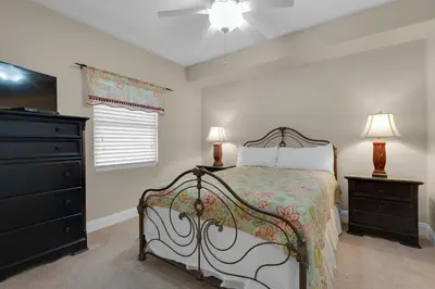 a bedroom with a bed and a dresser at Treasure Island 0210 in Panama City Beach