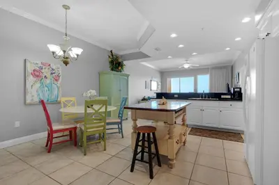 a kitchen with a table and chairs in a room at Treasure Island 0305 in Panama City Beach