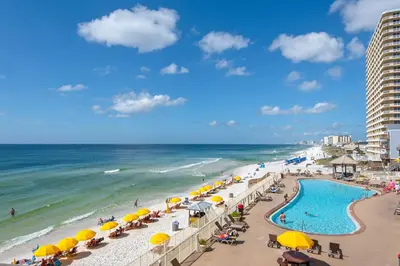 a beach with umbrellas and a swimming pool and the ocean at Treasure Island 0305 in Panama City Beach
