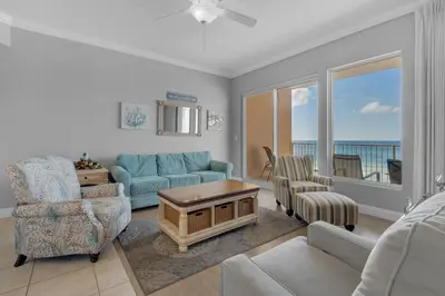 a living room with a blue couch and chairs at Treasure Island 0305 in Panama City Beach
