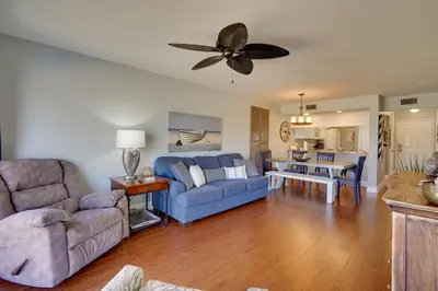 a living room with a blue couch and a ceiling fan at Nautical Edgewater Resort Condo - Walk to Beaches! in Panama City Beach