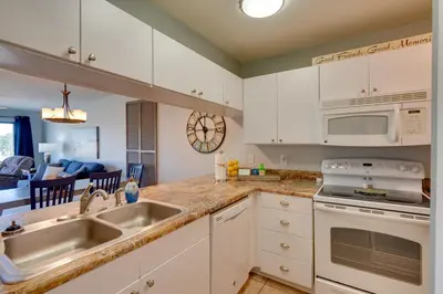 a kitchen with white cabinets and a sink at Nautical Edgewater Resort Condo - Walk to Beaches! in Panama City Beach