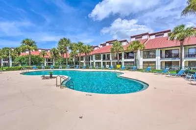 a swimming pool at a resort with chairs and a building at Nautical Edgewater Resort Condo - Walk to Beaches! in Panama City Beach