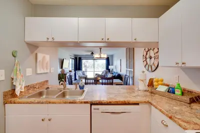 a kitchen with white cabinets and a sink at Nautical Edgewater Resort Condo - Walk to Beaches! in Panama City Beach