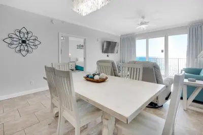 a white dining room with a white table and chairs at Grandview East 304 in Panama City Beach
