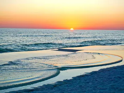 a sunset on a beach with the ocean at Grandview East 304 in Panama City Beach