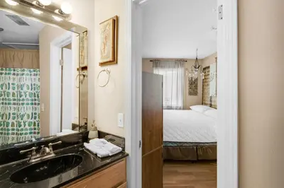 a bathroom with a sink and a mirror and a bed at Sandcastle Villas #24 in Panama City Beach