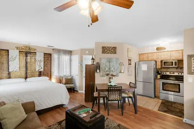 a bedroom with a bed and a kitchen with a table at Sandcastle Villas #24 in Panama City Beach