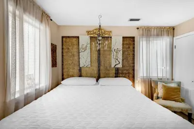a bedroom with a large white bed and a chair at Sandcastle Villas #24 in Panama City Beach