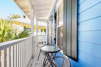 a balcony with a table and chairs on a house at Seagrove Bungalow 153 in Santa Rosa Beach