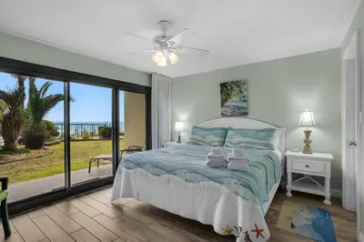 a bedroom with a bed with a view of the ocean at Commodore 107 (2/2) in Panama City Beach