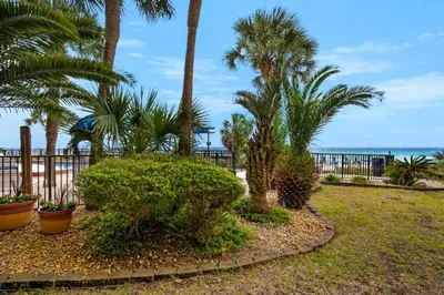 a park with palm trees and the ocean in the background at Commodore 107 (2/2) in Panama City Beach