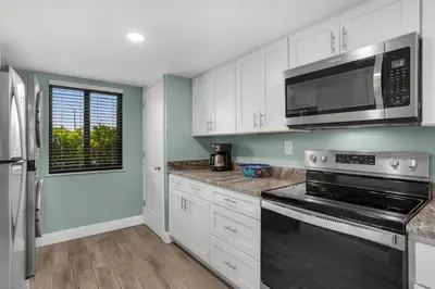 a kitchen with white cabinets and a microwave at Commodore 107 (2/2) in Panama City Beach