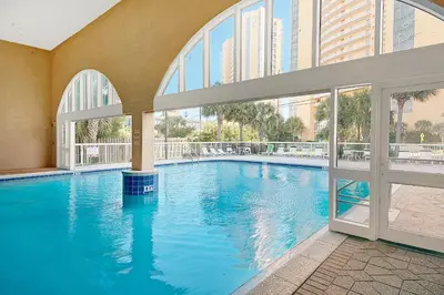 a large swimming pool in a building with windows at Celadon 1902 